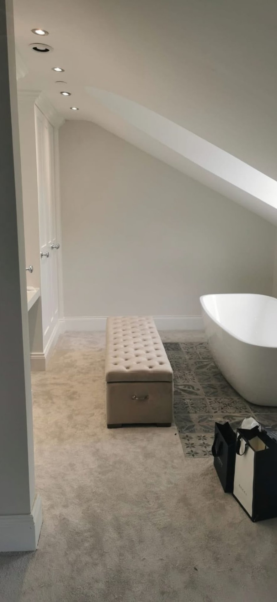 Attic bathroom with a repaired sloped ceiling and neat plaster finish