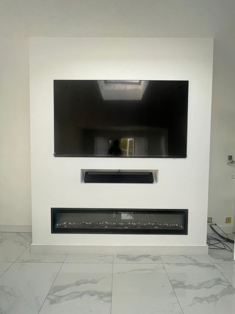 Smooth finished media wall with a recessed television and electric fire