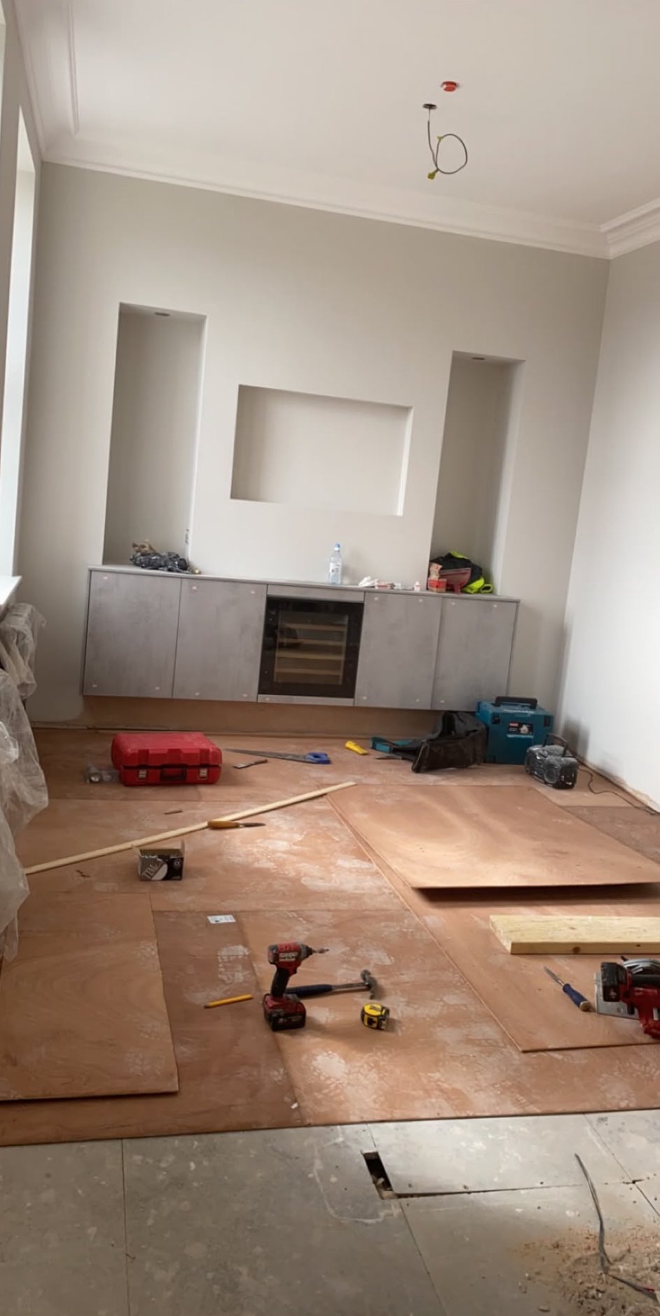 Dry lined wall with recessed alcoves and a television niche above fitted units